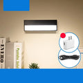 White rechargeable magnetic desk lamp with a large LED light panel attached to a metal bed frame.