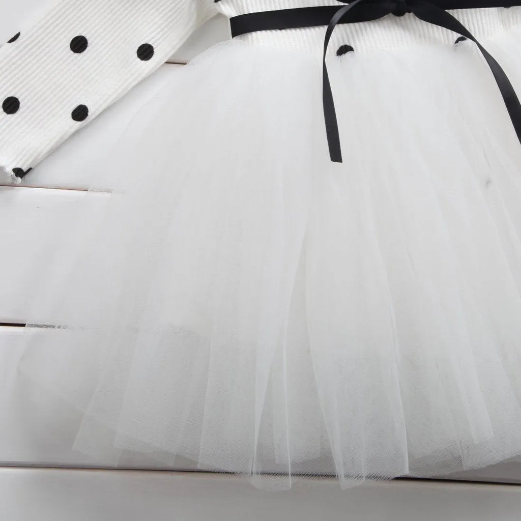 Baby girl wearing a long sleeve white lace tutu dress for a birthday party