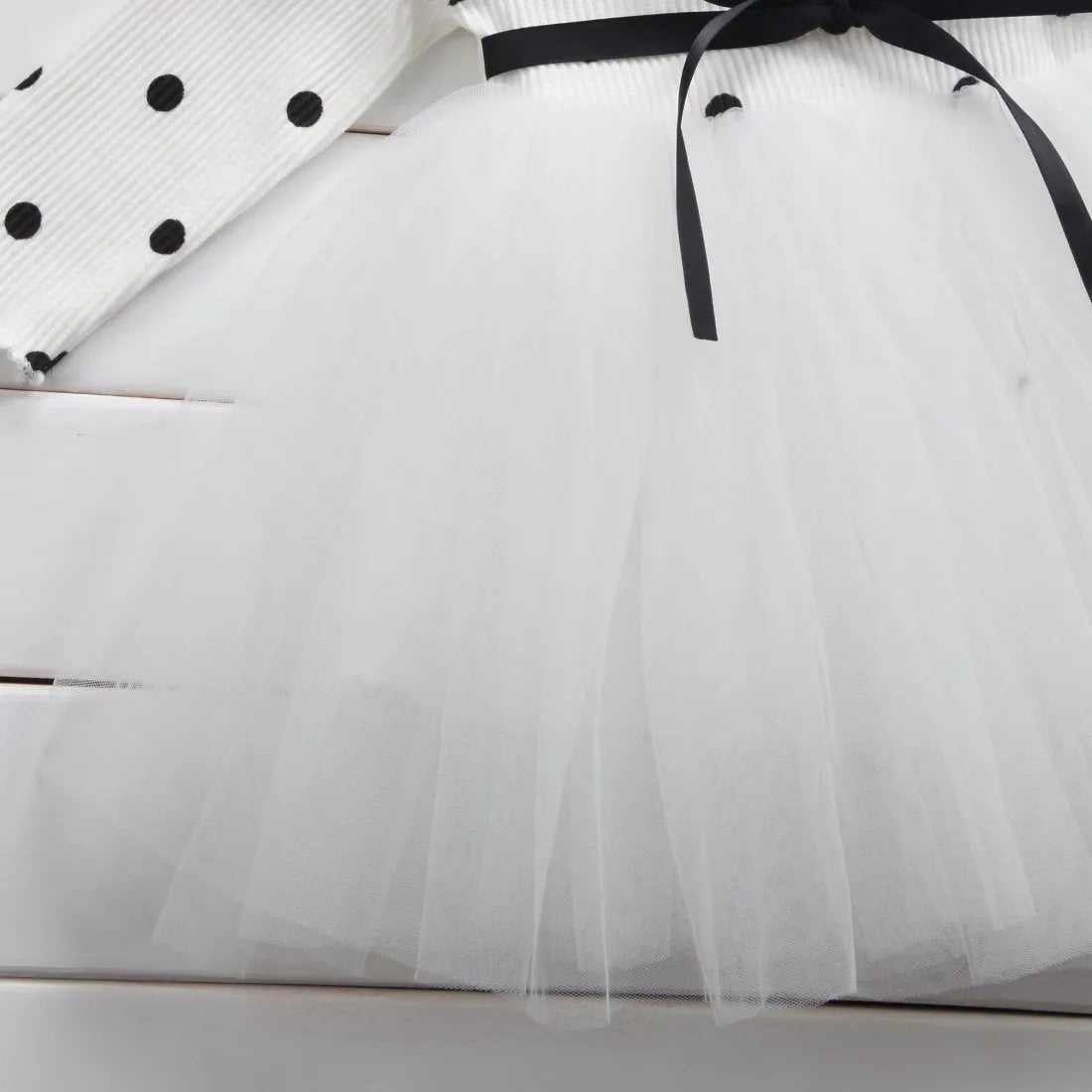 Baby girl wearing a long sleeve white lace tutu dress for a birthday party