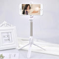 Apple-compatible black tripod selfie stand with Bluetooth remote and 360-degree rotating phone clip extended.