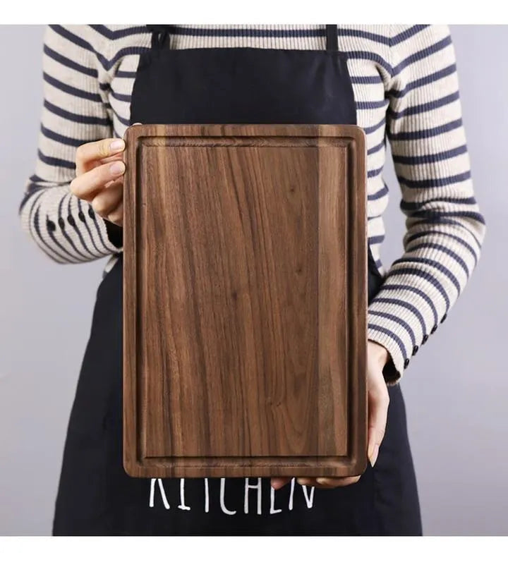 Black walnut wood cutting board with juice groove and side handle, shown in round and rectangular sizes.