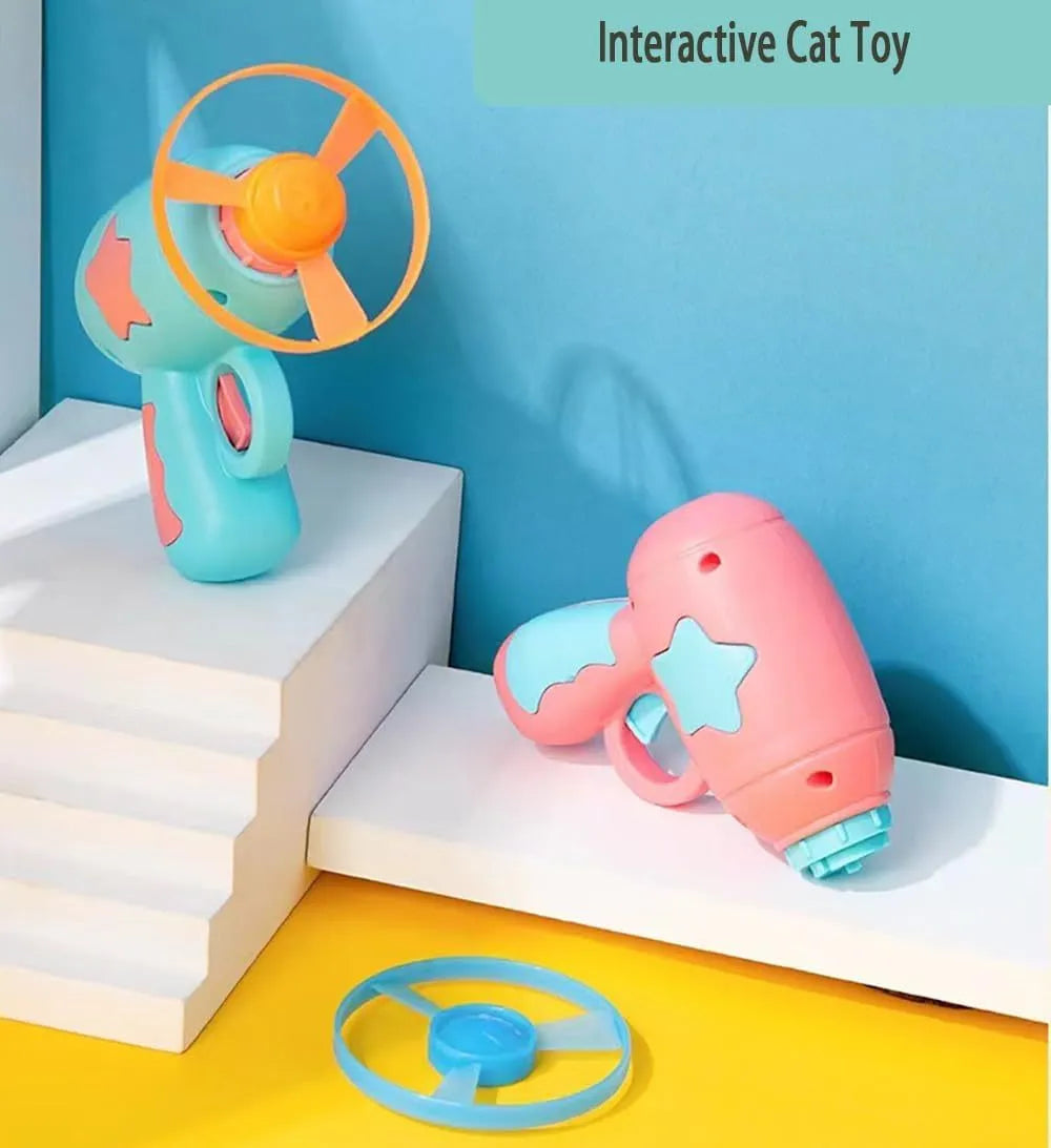 Blue interactive cat toy gun launcher with a mounted pink plastic frisbee, shown with a second frisbee disc.