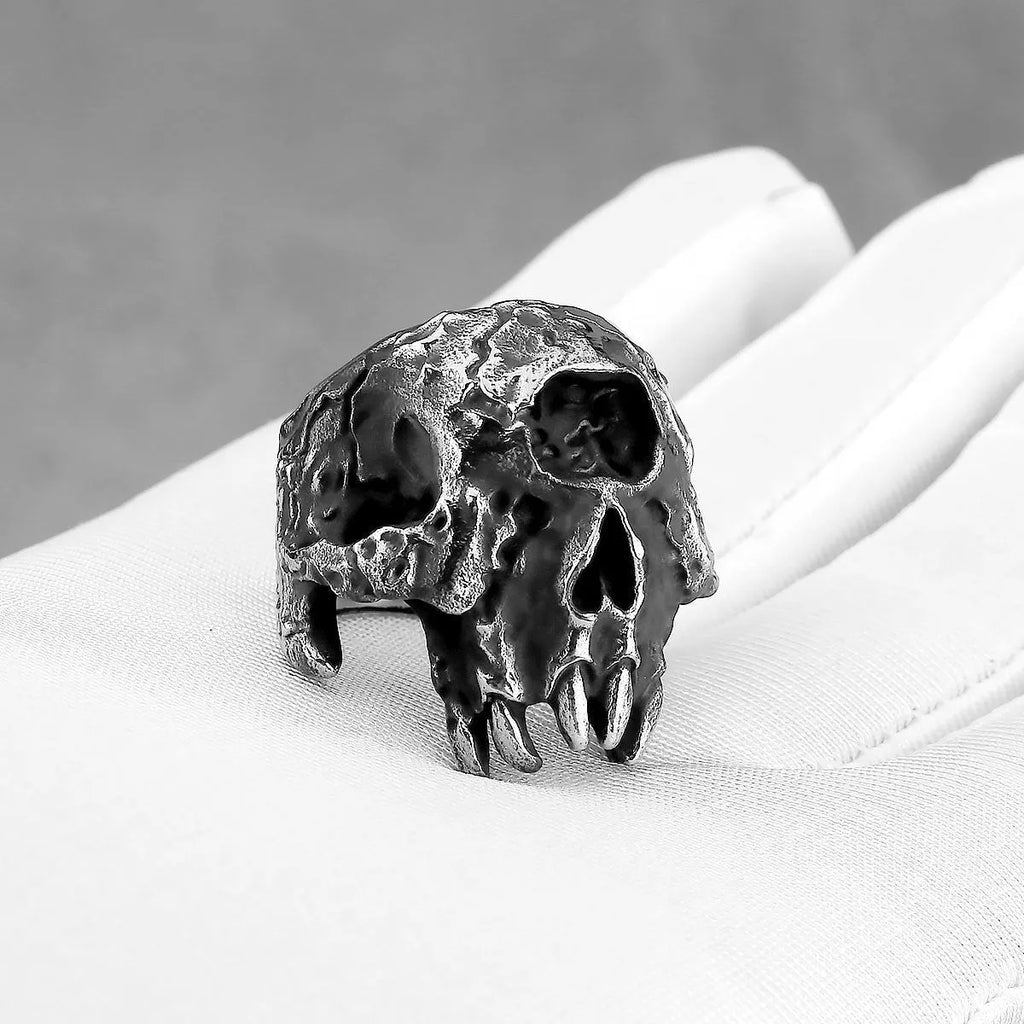 Close-up of a silver-toned alloy ring featuring a detailed one-eyed skull design on a black background.