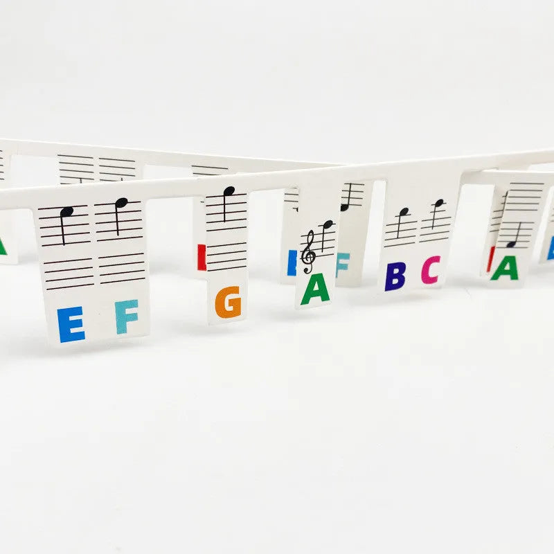 Piano keyboard note stickers on white cardboard for 88 keys, showing separate packs for black notes and colour note bars.