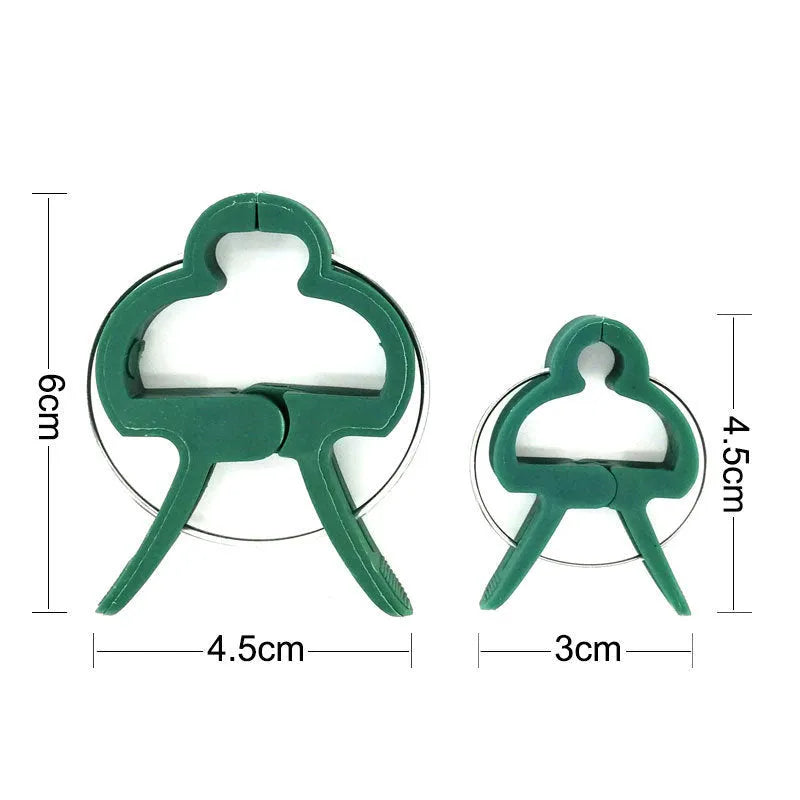 Green plastic plant fixing clips holding tomato vine to garden stake