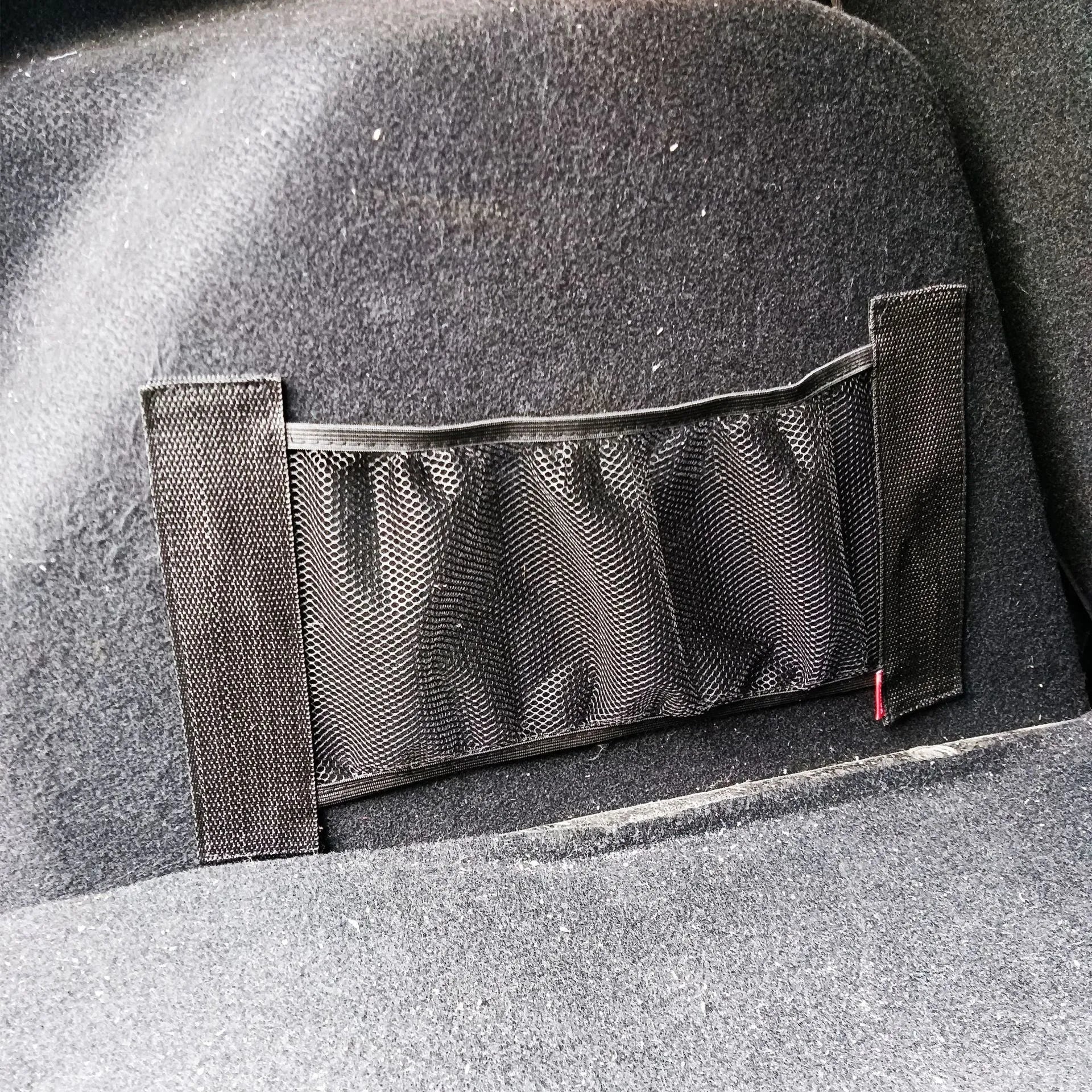 Grey elastic polyester car trunk storage net organiser in two size options.