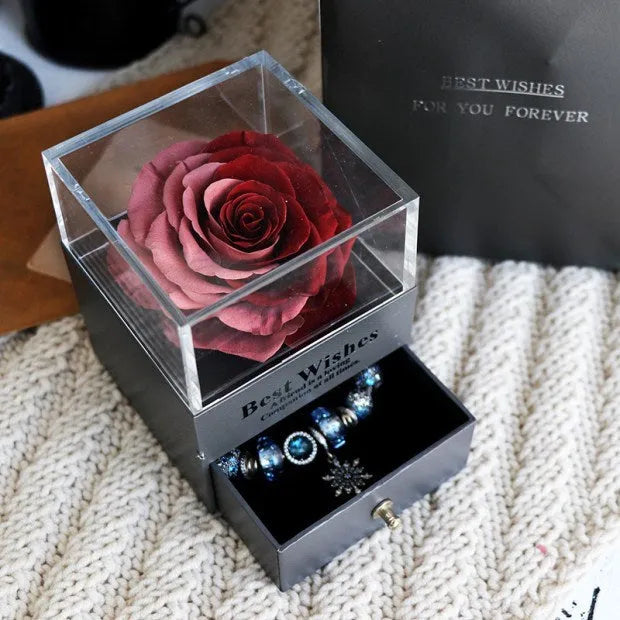 Glass eternal flower jewellery box with preserved roses and carnations inside measuring 8.5cm square