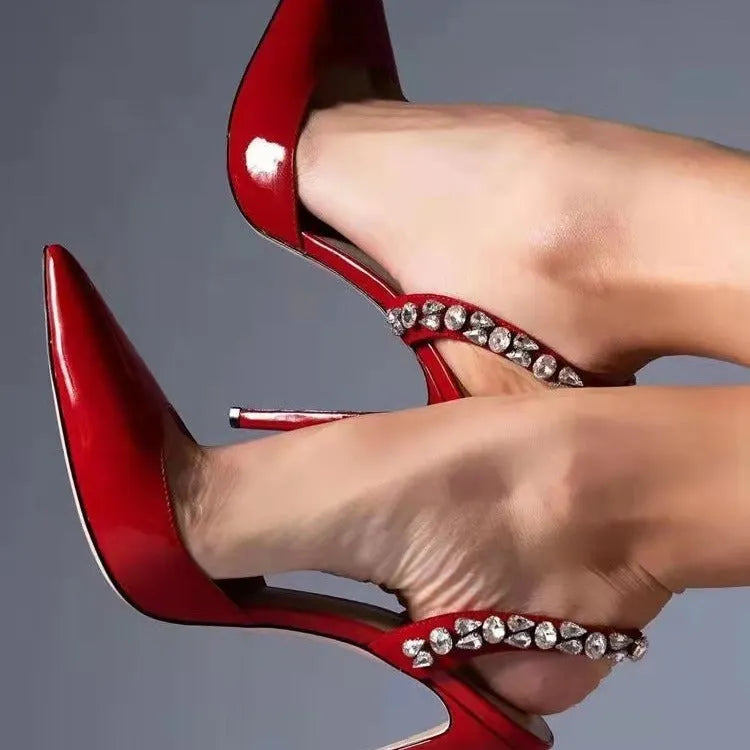 Women's black patent leather pointed toe high heel sandals with rhinestone detail on the side.