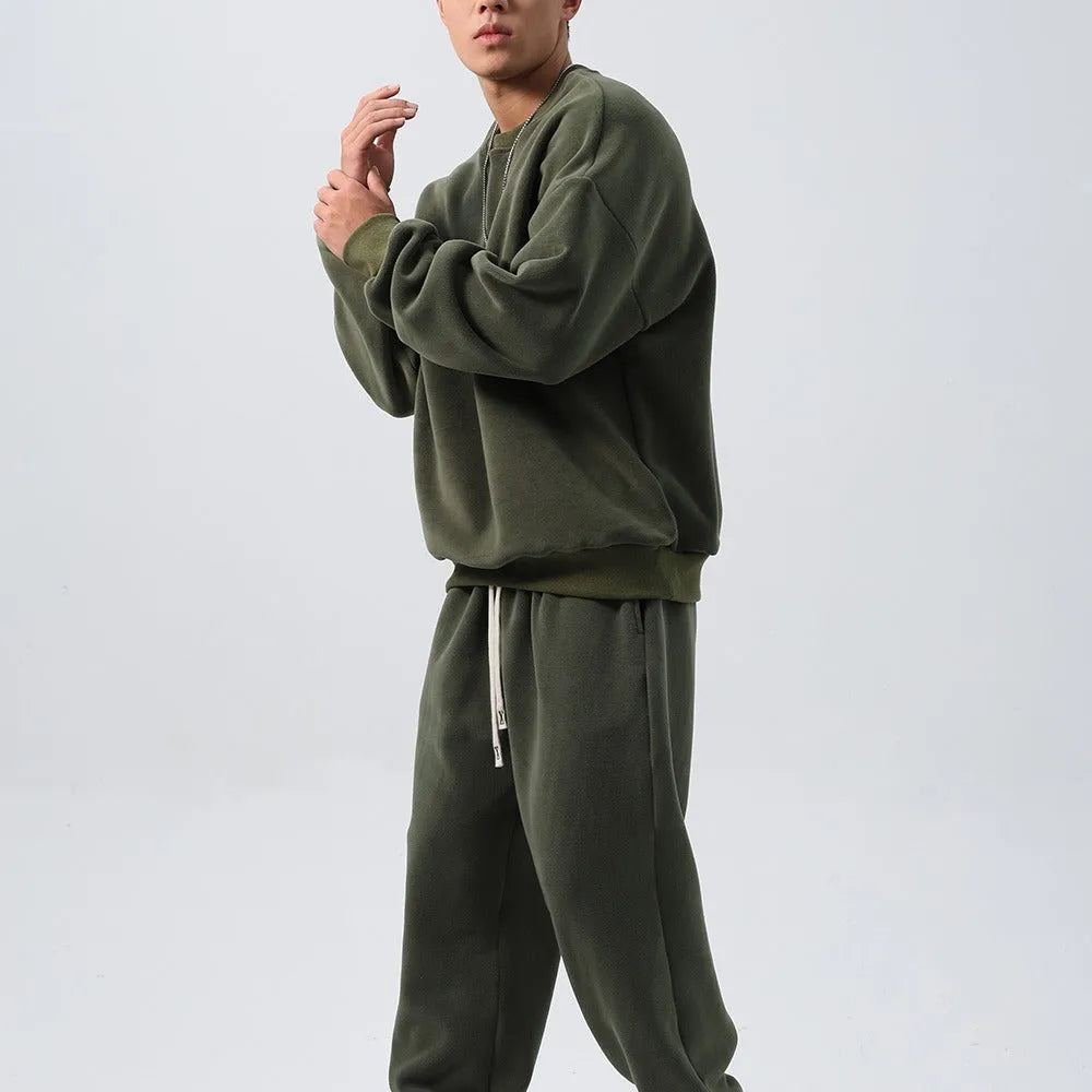 Men's polar fleece sports suit showing loose long sleeve coat and padded trousers in army green.