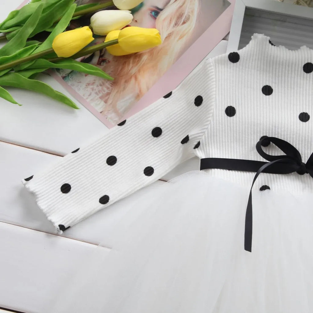 Baby girl wearing a long sleeve white lace tutu dress for a birthday party
