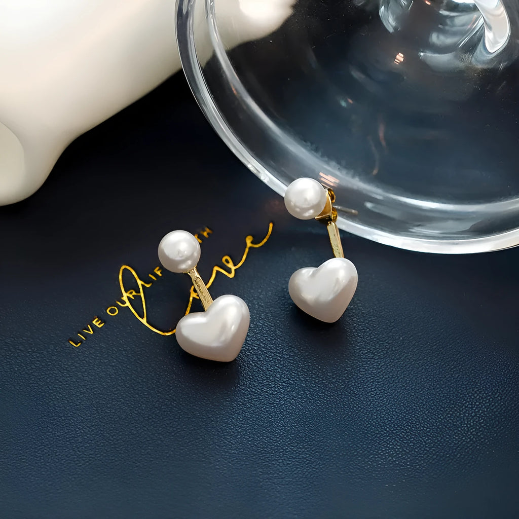 Close-up of a women's heart-shaped alloy stud earring with electroplated finish and central gemstone inlay.