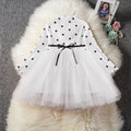 Baby girl wearing a long sleeve white lace tutu dress for a birthday party