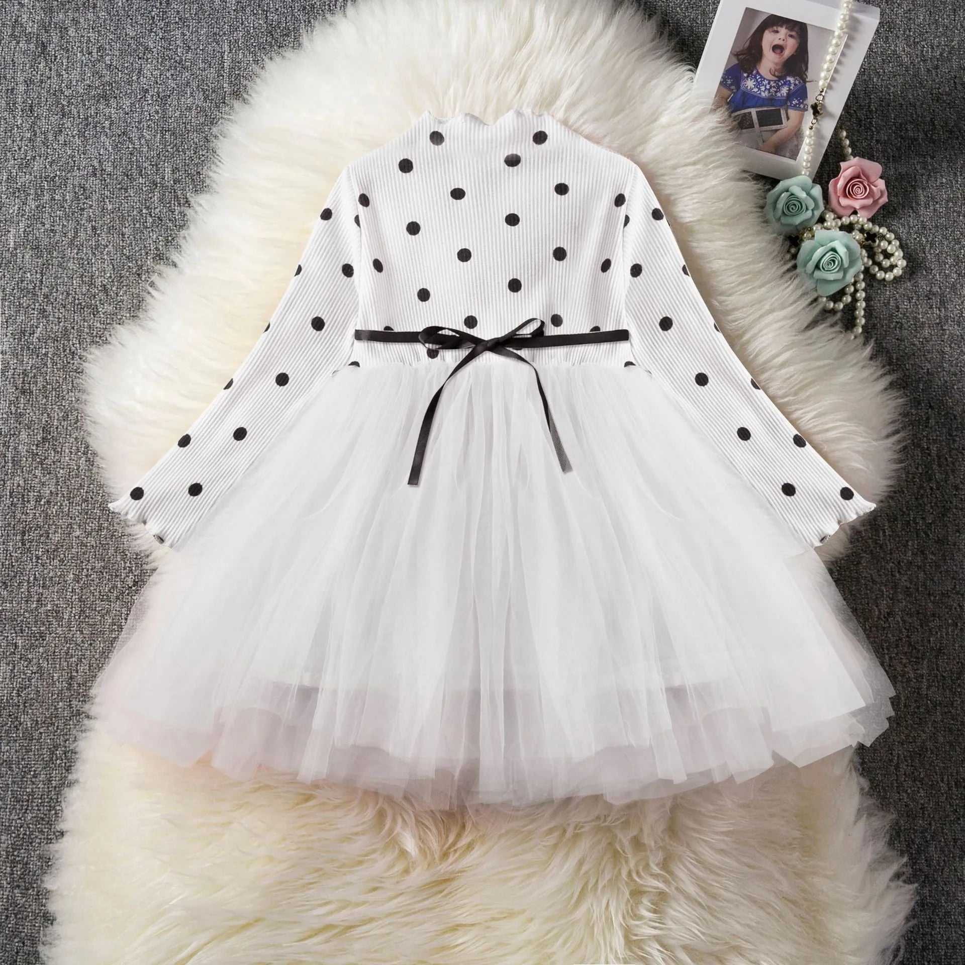 Baby girl wearing a long sleeve white lace tutu dress for a birthday party