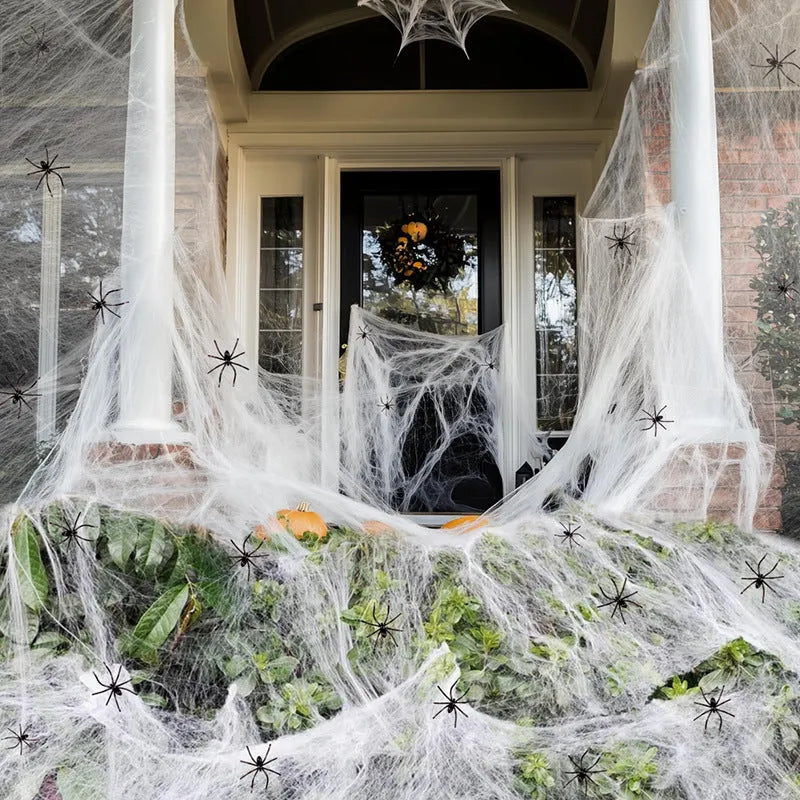 White cotton spider Halloween decoration web with plastic spiders draped across furniture