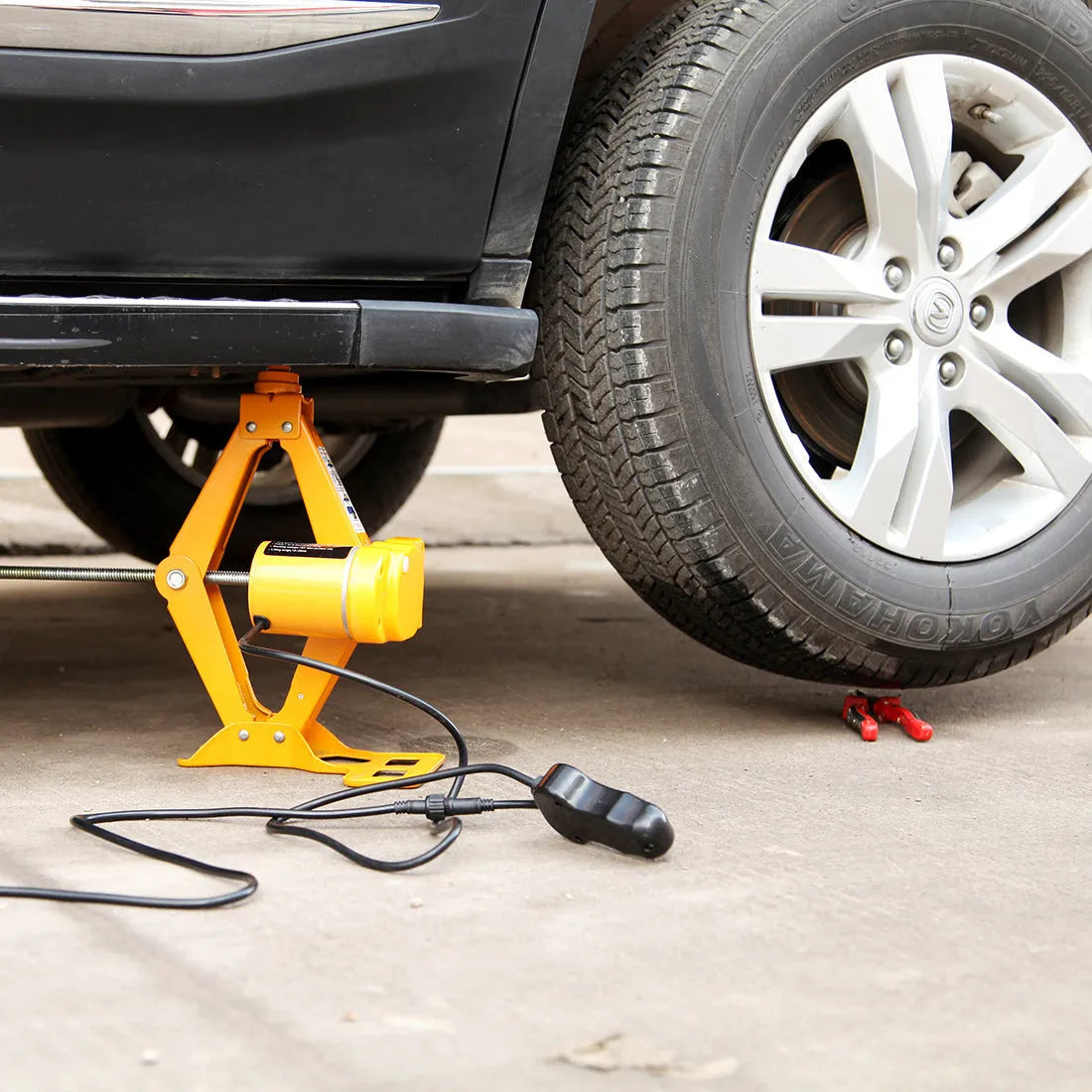 Electric hydraulic vehicle jack kit with 2 tonne capacity mounted in car for roadside assistance