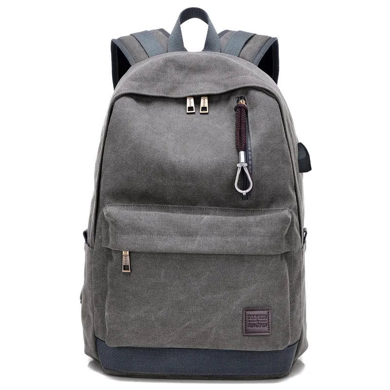 Canvas backpack in grey colour showing USB charging port, front zipper pocket, and adjustable shoulder straps