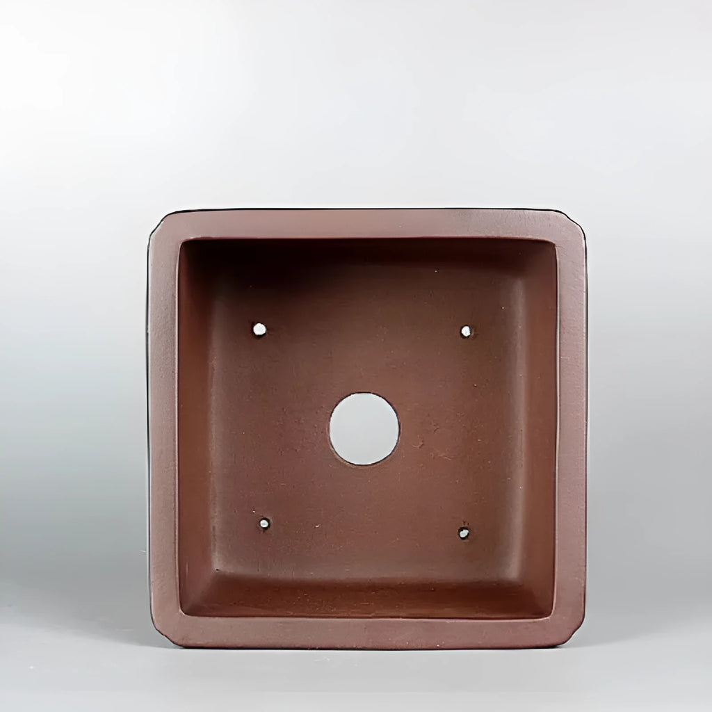 Brown handmade antique purple clay flower pot with classical style on a surface