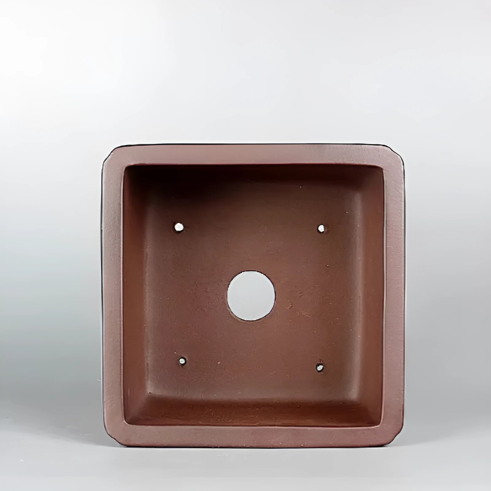 Brown handmade antique purple clay flower pot with classical style on a surface