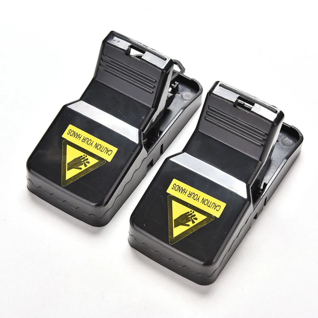 Six black plastic snapping mousetraps showing size and smooth surface.