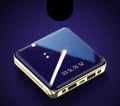 Compact square blue power bank with multiple USB ports, showing scale next to a mobile phone.