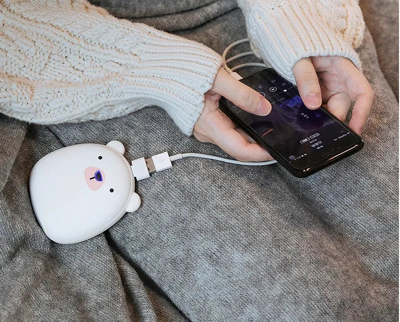 USB rechargeable electric hand warmer with penguin polar bear design showing front and back heating surfaces