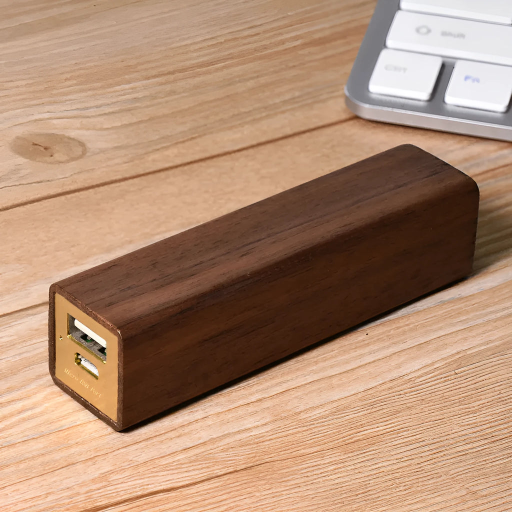 Brown walnut wood portable power bank with USB port next to its gift box.