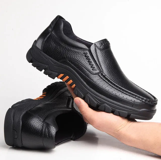 A pair of black and brown business casual leather shoes with a rubber sole, shown from the side.