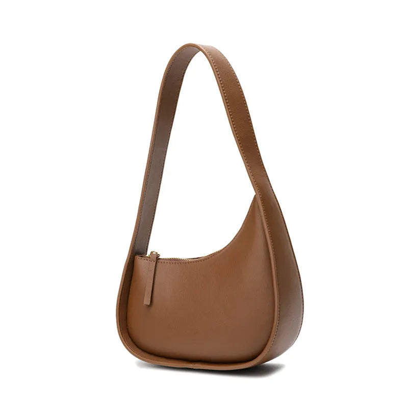Small half-moon shaped leather ladies handbag with wide shoulder strap and zip opening