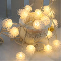 Warm white LED pine cone decorative light string powered by two AA batteries.