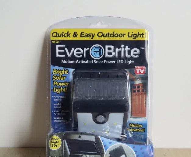 Four solar-powered LED outdoor sensor lights with wall mounting hardware