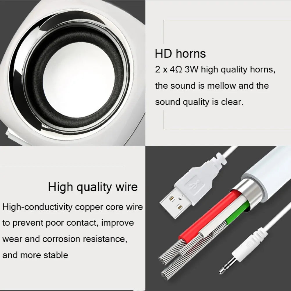 Pair of mini desktop speakers with 3.5mm audio plug on desk beside laptop