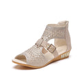 Women's beige wedge sandals with a back zipper and low heel on a white background.