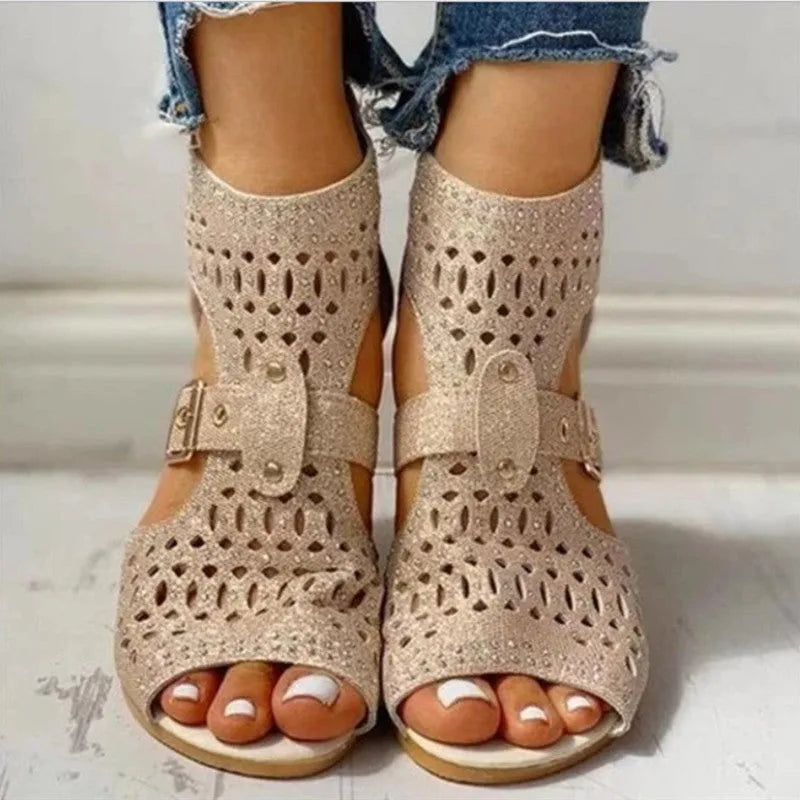 Women's beige wedge sandals with a back zipper and low heel on a white background.