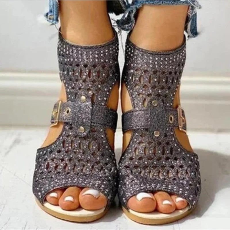 Women's beige wedge sandals with a back zipper and low heel on a white background.