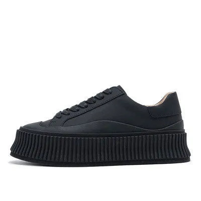 Women's black suede platform sneakers with a thick sole and back lacing system.
