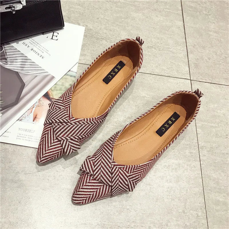 Red and black women's pointed toe casual shoes with a low flat heel on a white background.