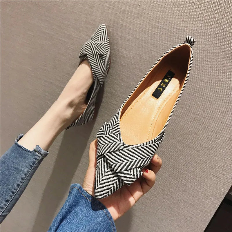 Red and black women's pointed toe casual shoes with a low flat heel on a white background.