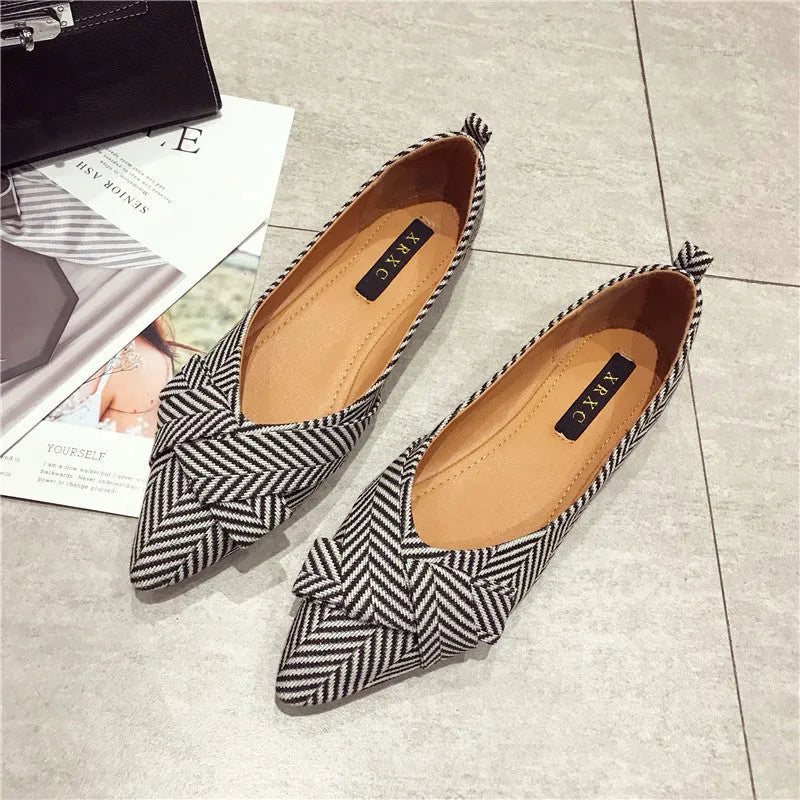 Red and black women's pointed toe casual shoes with a low flat heel on a white background.