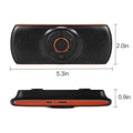 Orange Bluetooth car hands-free speaker mounted on car sun visor with wireless smartphone connectivity.
