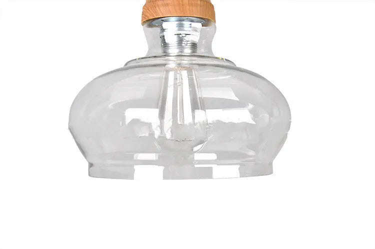 Glass single head pendant light with wood grain finish and adjustable cable, shown in a Nordic style interior.