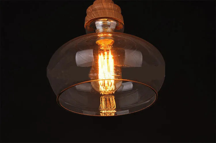 Glass single head pendant light with wood grain finish and adjustable cable, shown in a Nordic style interior.
