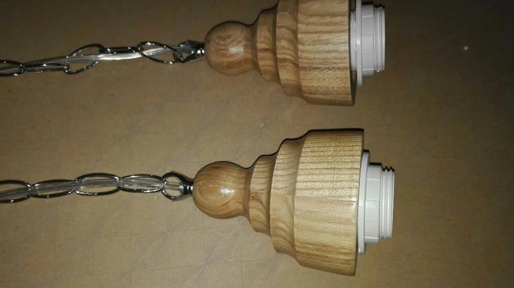 Glass single head pendant light with wood grain finish and adjustable cable, shown in a Nordic style interior.