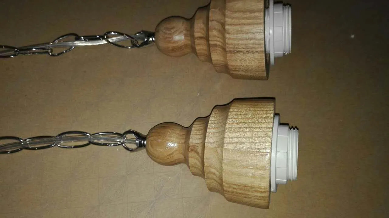 Glass single head pendant light with wood grain finish and adjustable cable, shown in a Nordic style interior.