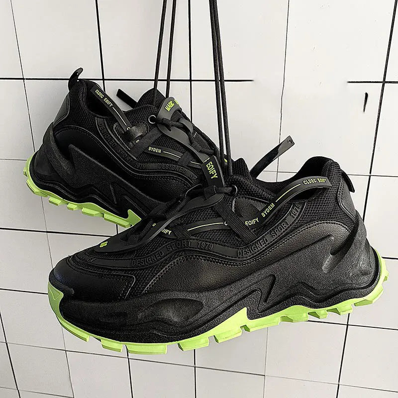 White and black chunky trainers with breathable mesh upper, thick rubber sole, front laces, and round toe