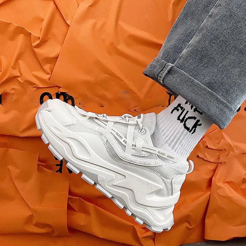 White and black chunky trainers with breathable mesh upper, thick rubber sole, front laces, and round toe