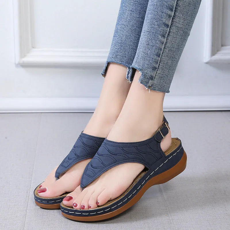 Women's black wedge heel sandals with an adjustable back strap buckle on a white background.