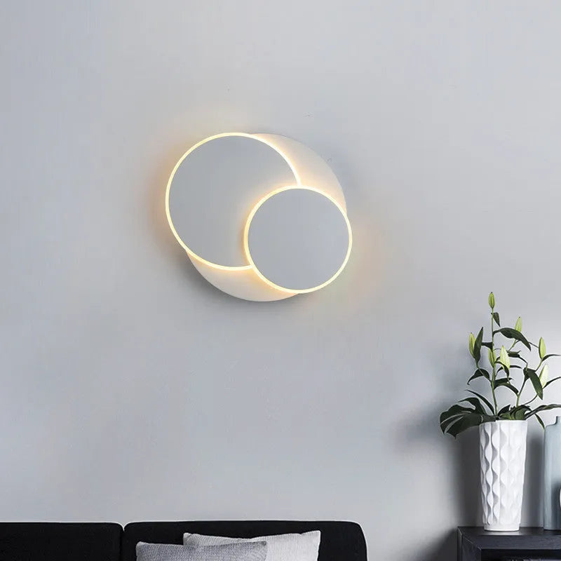 Modern round acrylic LED wall lamp with push button switch in black or white.