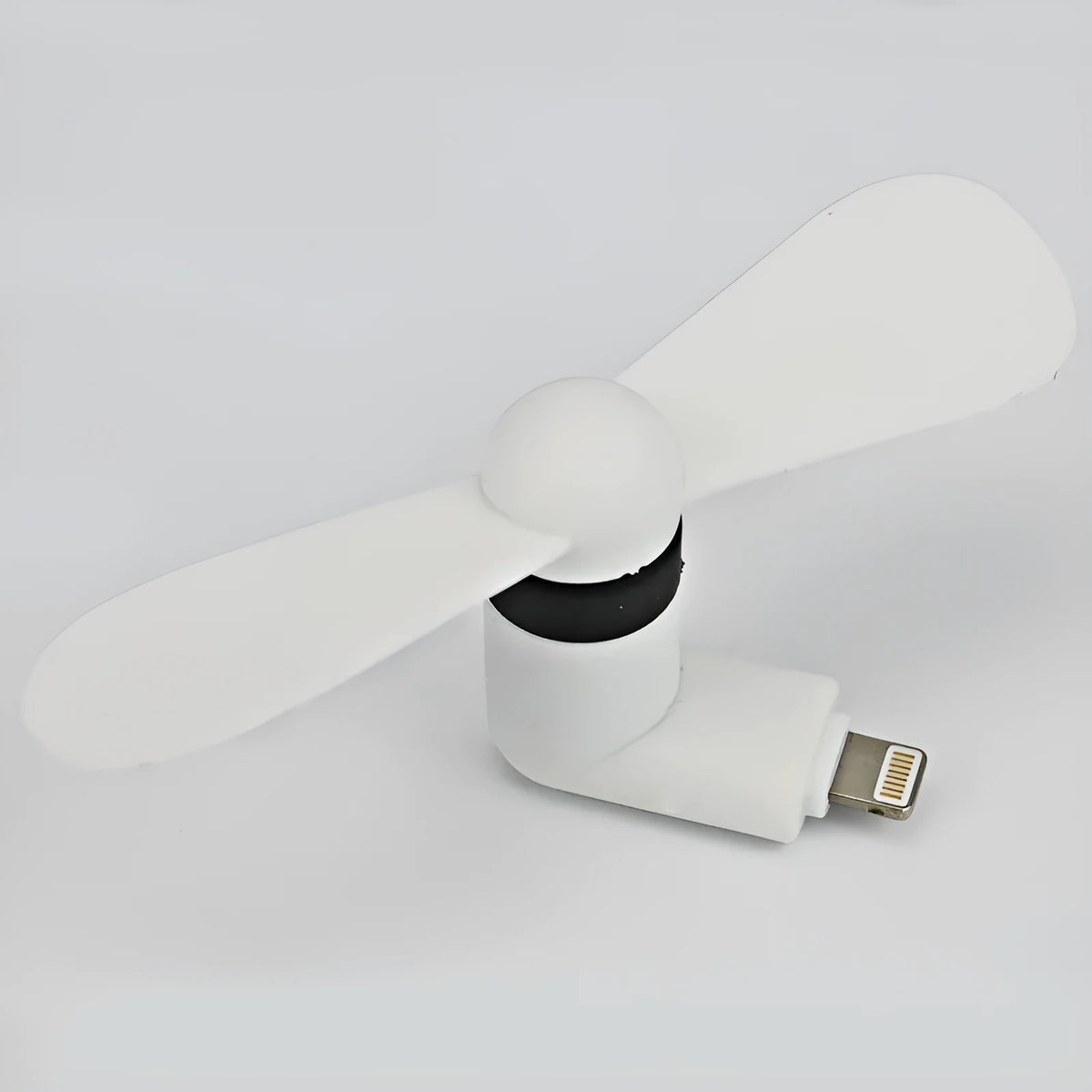 Portable white mini fan with plastic blades connected to a smartphone showing rotary switch.