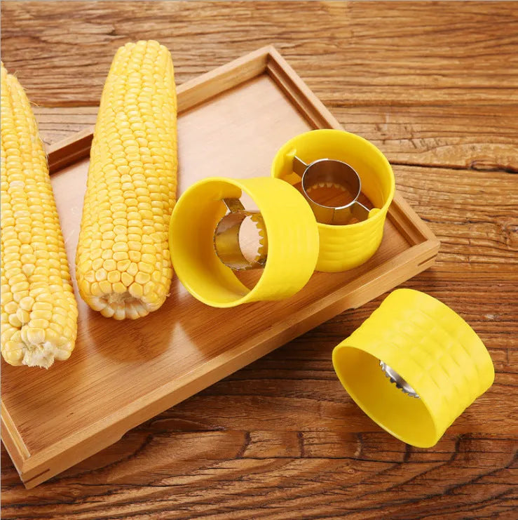 Yellow manual corn grinder thresher kitchen tool with corn-shaped design on a white background.
