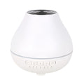White round Bluetooth humidifier and aroma diffuser with night light on wooden surface